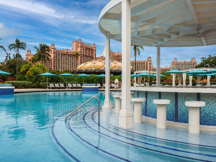 The in-pool Coral Bar at Atlantis Paradise Island with steps in the pool leading up to a circular bar with stools in the pool.
