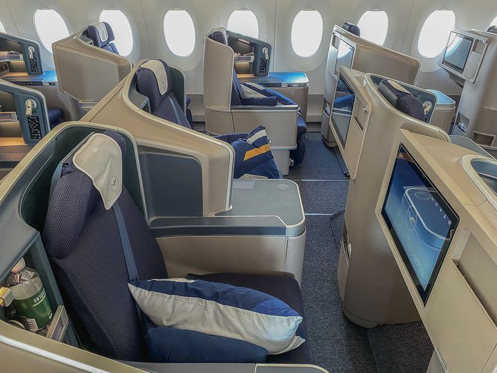 A Lufthansa Business Class cabin with empty seats that lie flat.