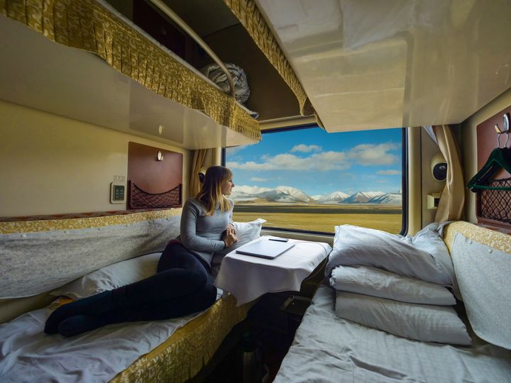 A woman on a sleeper train looking out the window.