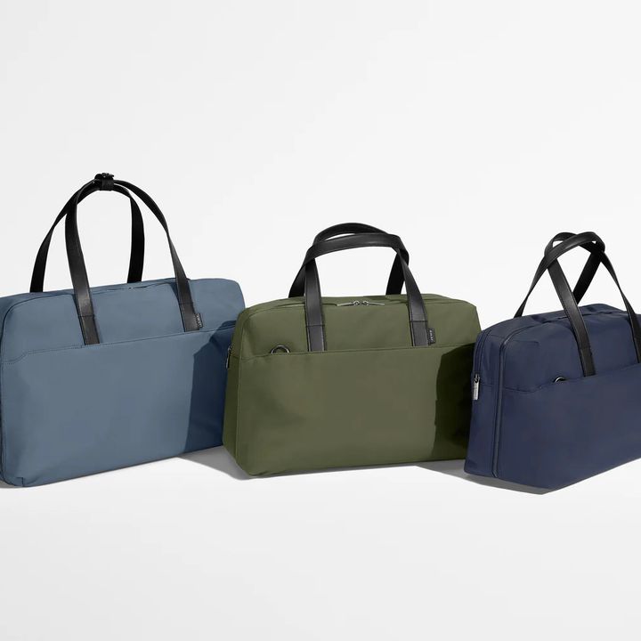 Three Away Weekender bags in three different colors and sizes.