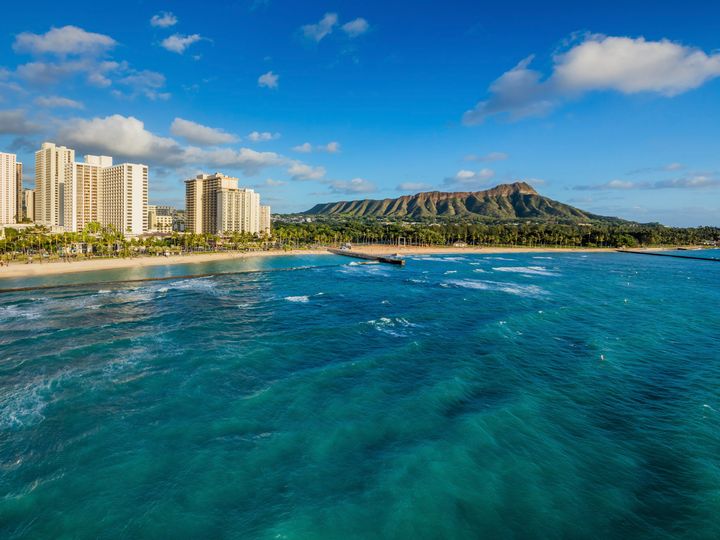 A view of the Waikiki Beach Marriott Resort & Spa as seen from the ocean looking back over the beach and Diamond Head.