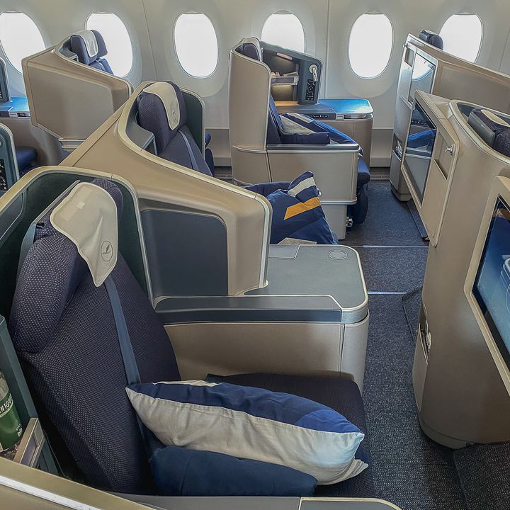 A Lufthansa Business Class cabin with empty seats that lie flat.