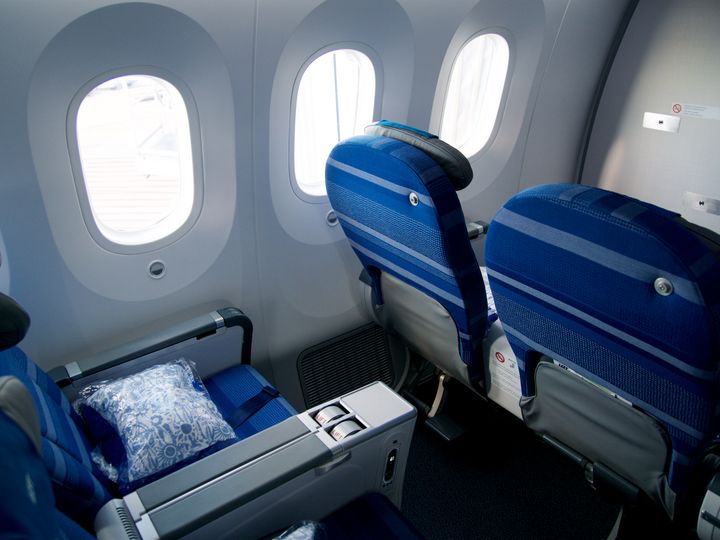 Four premium economy seats inside a plane.