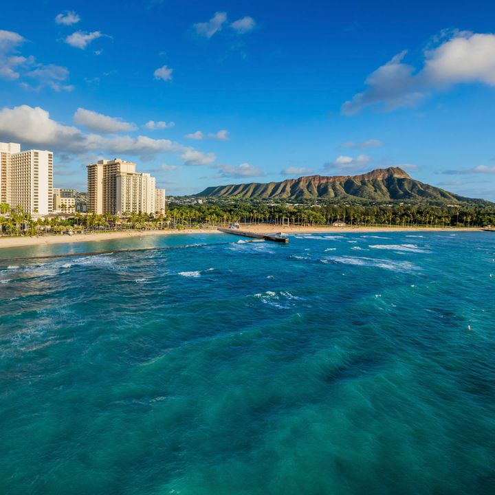 A view of the Waikiki Beach Marriott Resort & Spa as seen from the ocean looking back over the beach and Diamond Head.