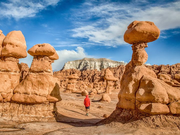 A hiker in the middle of hoodoo rocks in Goblin Valley State Park, Utah.