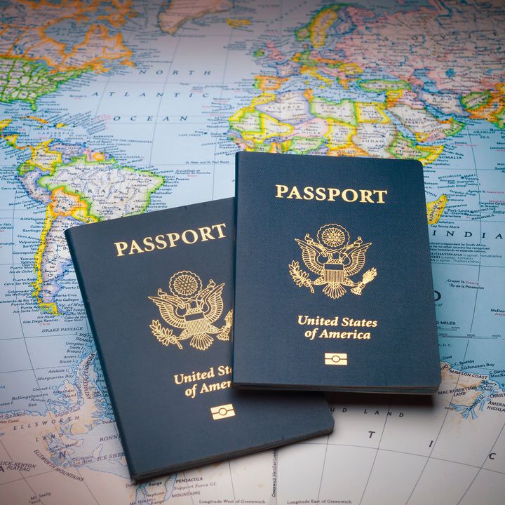 Two travel passports sitting on top of a world map.