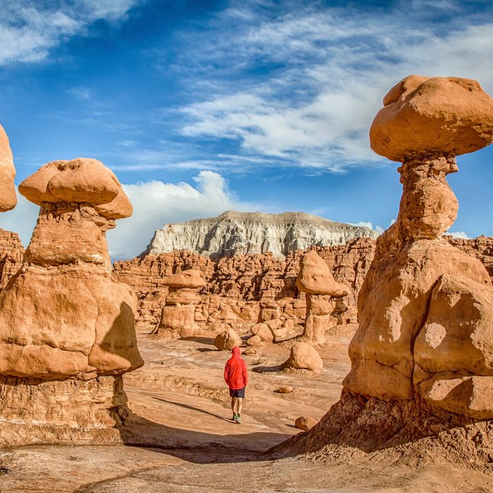 A hiker in the middle of hoodoo rocks in Goblin Valley State Park, Utah.