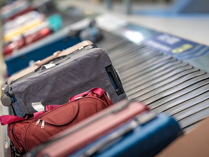 Suitcases sitting on a baggage carousel belt.