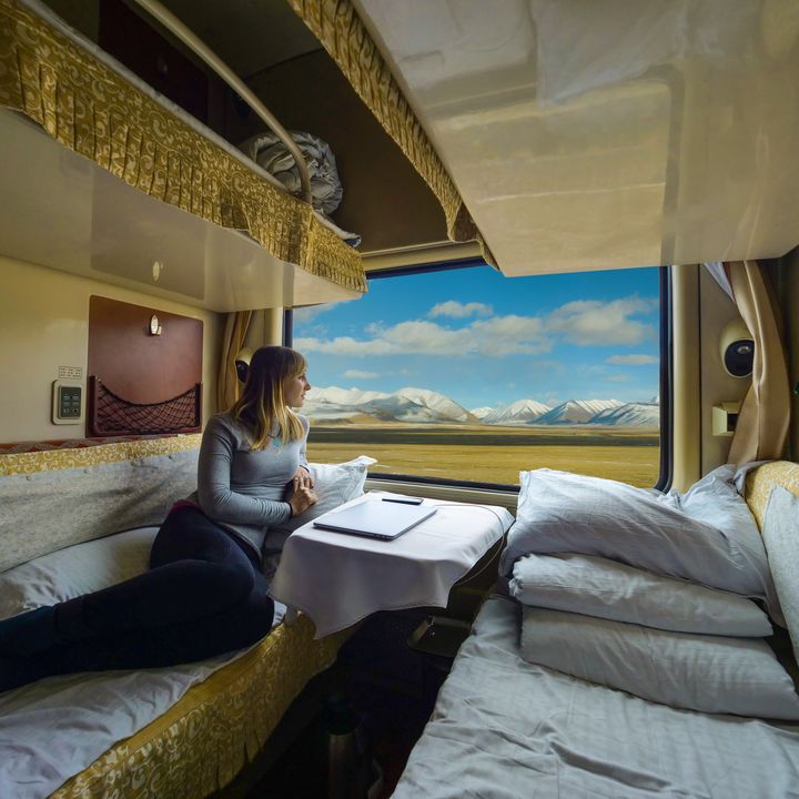 A woman on a sleeper train looking out the window.