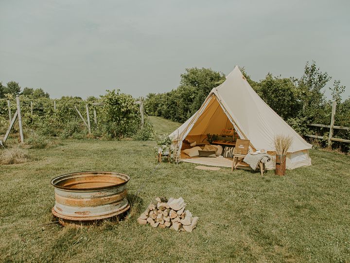 A glamping tent at Wild Mountain Winery with a fire pit and vineyard.