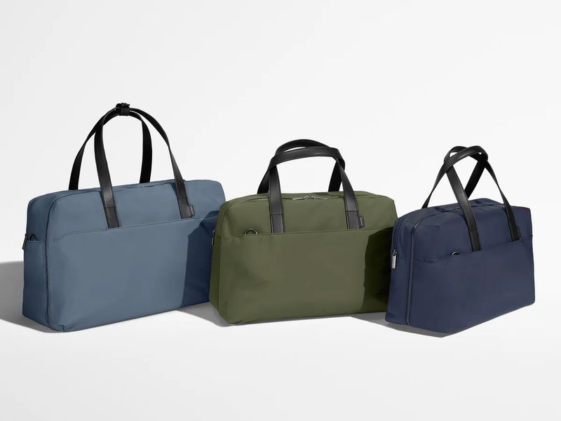 Three Away Weekender bags in three different colors and sizes.