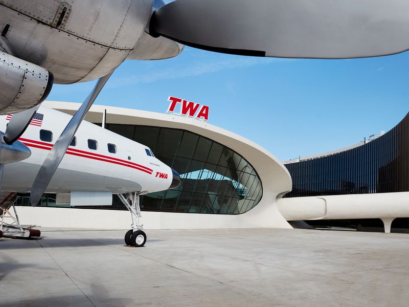 An old TWA plane is parked next to the TWA Hotel at JFK.