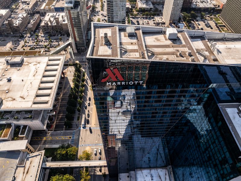An aerial view looking down over a Marriott hotel set in an urban city.